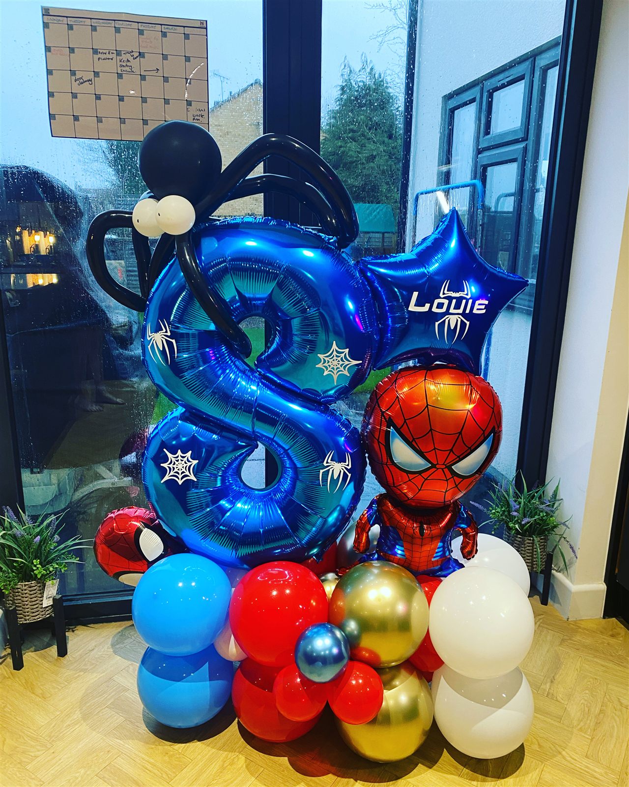 Superhero themed blue number 8 balloon stack